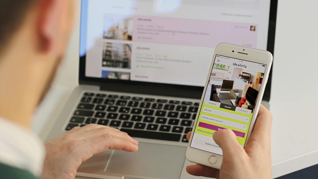 Una persona consulta en su móvil la página Web de Idealista