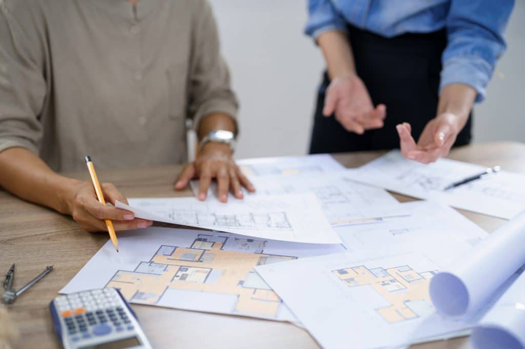 Equipo de asesores inmobiliarios trabajando sobre el plano de unas viviendas.